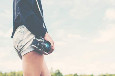 beautiful women photography standing hand holding retro camera in the park.