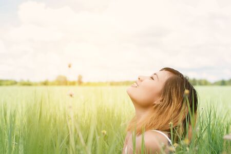 young beautiful woman sitting on grassland enjoy nature and fresh air happy.の写真素材