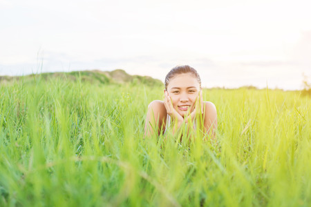 Beautiful Young Woman,Healthy Smiling woman Relaxing in Green Grass at meadows.の写真素材
