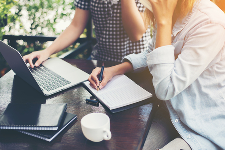 Two young businessmen meeting and working at cafe with soft retro tone.の写真素材