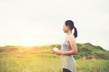 young beautiful asian woman enjoy life and coffee at meadows in the morning.の写真素材