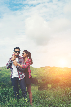 Young hipster couple holding hands walking on the meadow relaxing and natural atmosphere is very natural.の写真素材