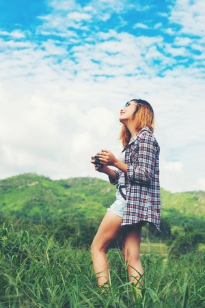 Young Hipster Woman with retro camera taking shot outdoor landscape ,Lifestyle mountain nature on background.の写真素材