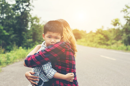 Little cute asian boy hug with her mom and smiling to camera happy time.の写真素材