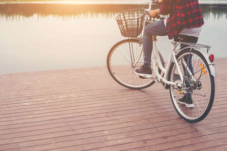 Close-up of young hipster woman holding her foot on bicycle pedal.の写真素材