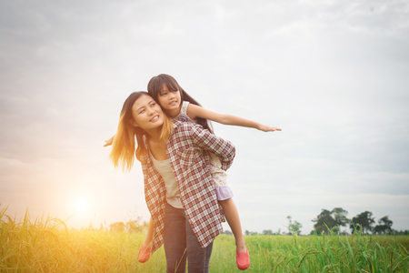 Portrait mom and daughter playing outdoor, enjoying family time.の写真素材