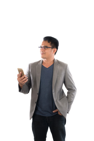 Young hipster man holding his smart phone standing isolated on white background.の写真素材