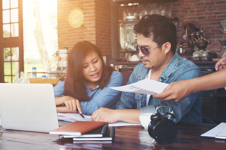 Two young business working on their laptop, While sitting in a cafe, Talking serious with work. Business life concept.の写真素材