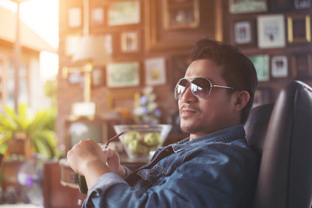 Young man with smartphone smiling relaxing at cafe.の写真素材