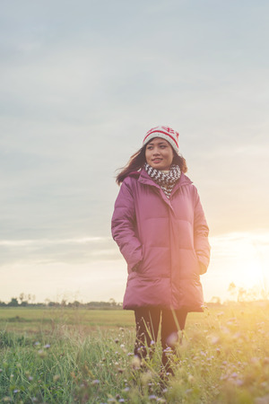 Young woman was playing in a field of flowers in the winter air.の写真素材