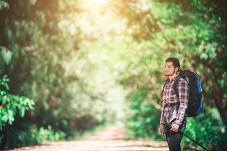 Hipster man hiker holding poles and looking away.の写真素材
