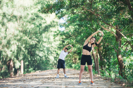 Man and woman stretching together at the park.の写真素材