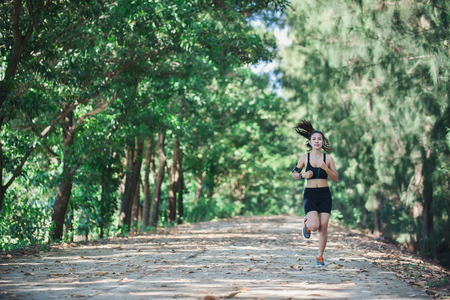 Young fitness woman jogging in park.の写真素材