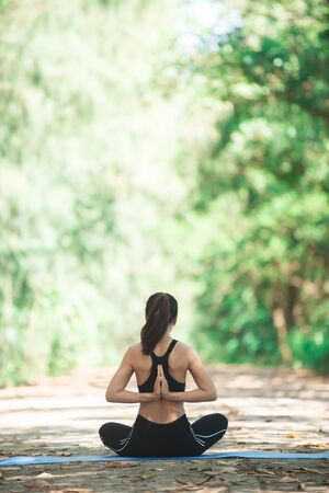 Young asian woman doing yoga in the morning at the park. Healthy lifestyle concept.の写真素材