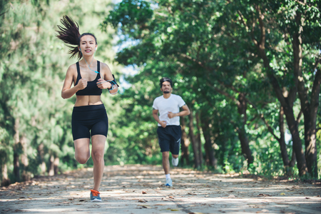 Young couple running in the park.の写真素材