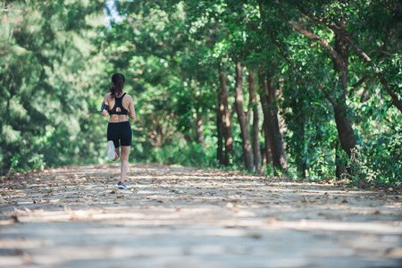 Young fitness woman jogging in park.の写真素材