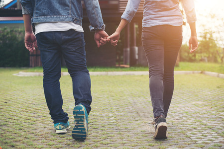 Close-up of loving couple holding hands while walking outdoor, Couple in love concept.の写真素材