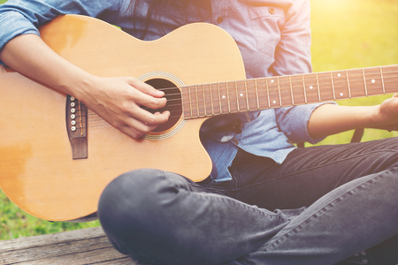 Musician woman and her guitar in nature park, Practice guitar.の写真素材