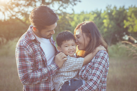 Happy young family spending time together outside in green nature park. Family love concept.の写真素材