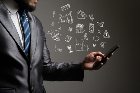 Businessman hands using smartphone with doodle business icons. Communication concept.の写真素材