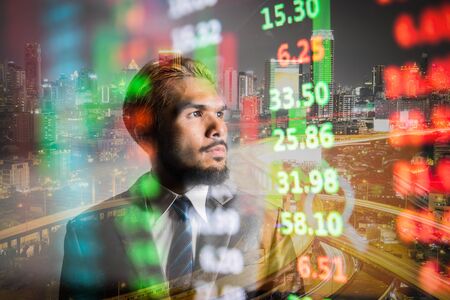 Business manwith modern visual technology for trading to sell in  stock market with index graph and...