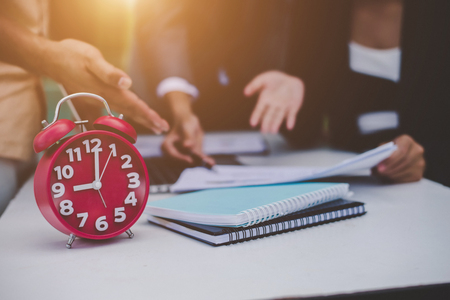 Business partners discussing documents and ideas at meeting.の写真素材