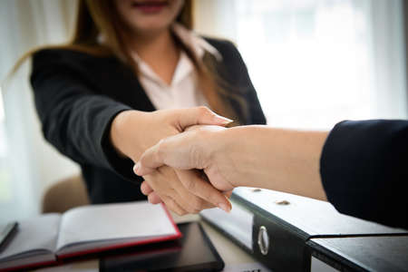 Business people shaking hands while sitting at the working place, Finish success business good deals meeting partnershipの写真素材