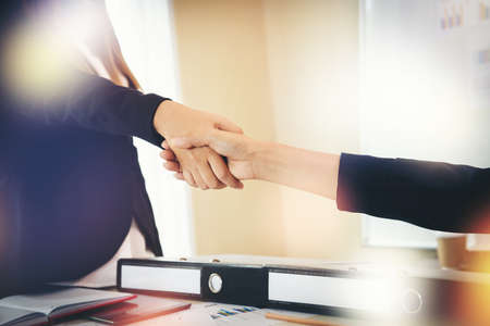 Business people shaking hands while sitting at the working place, Finish success business good deals meeting partnershipの写真素材