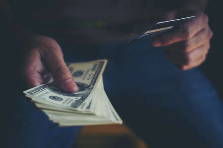 Hands holding dollar money with credit card for shopping online.の写真素材