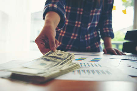 Young business woman hand check dollar banknote. Planning concept.の写真素材