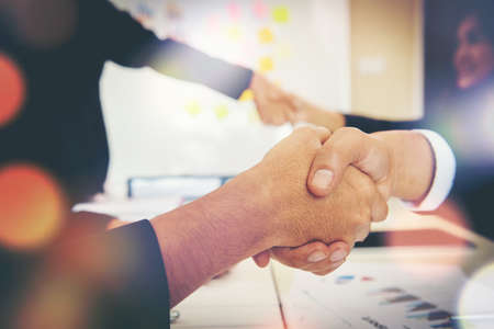 Business people shaking hands while sitting at the working place, Finish success business good deals meeting partnershipの写真素材