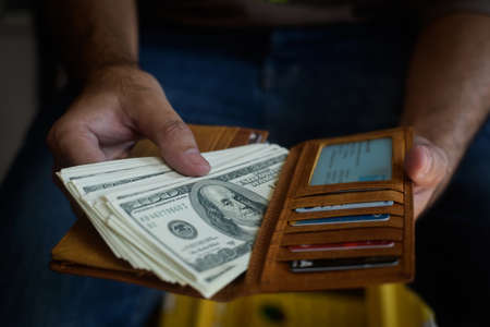 Hands taking out dollar us money from walletの写真素材