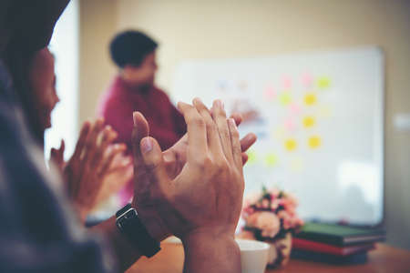 Happy group of business people clapping in office meeting hands applauding at conference success and perfect presentation.の写真素材