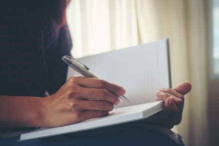 Business woman writing down her ideas in notebook. Planing concept.の写真素材