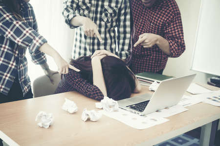 Depressed business woman with business people finger point to her. showing fail .の写真素材