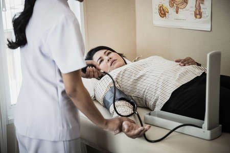 Close up of Young Nurse take care for elderly patients measuring pressure during admit in hospital.