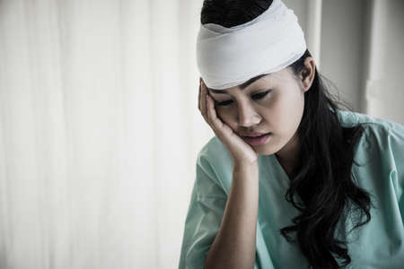 Female patients having pain in her head after hospitalization sitting on wheelchair in patient's...