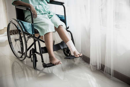 Close up of  patient's leg is splinted sitting a wheelchair in the patient's room.の写真素材