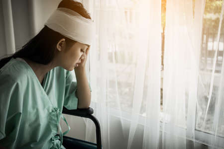 Female patients sitting on wheelchairs have pain after hospitalization.の写真素材