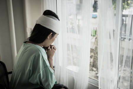 Female patients sitting on wheelchairs have pain after hospitalization.の写真素材