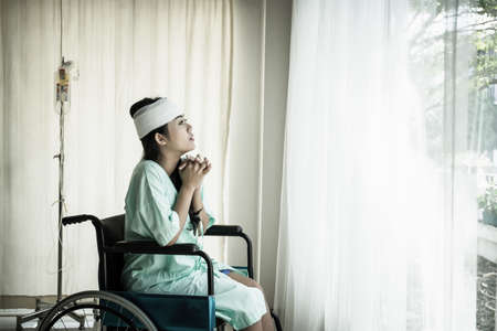 Female patients sitting on wheelchairs have pain after hospitalization.の写真素材