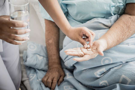 Nurse giving senior woman medical pills.の写真素材