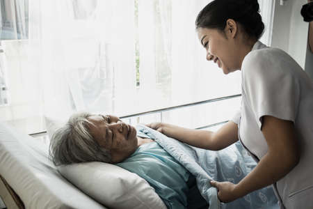 Young nurse take care of senior patient In Hospital Room