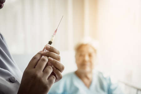 Aged patient being afraid of needle, does not want to take her treatment.の写真素材