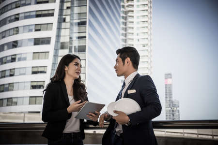 Business colleagues take a look at the work in the tablet together.の写真素材