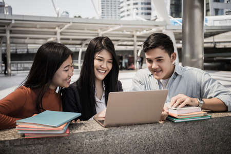 Group of students studying researching on laptop Together sitting at college.の写真素材