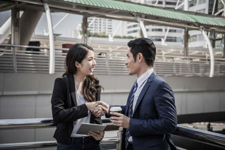 Business partner work hands shaking while looking at successful work at tablet. Business concept.の写真素材