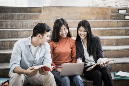 Group students studying researching on laptop Together sitting at college.の写真素材