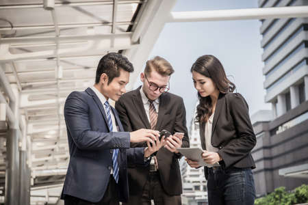Businessmen talk about work while meeting outside, business partners work together.の写真素材