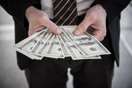 Close up of Businessman holding dollar bills.の写真素材